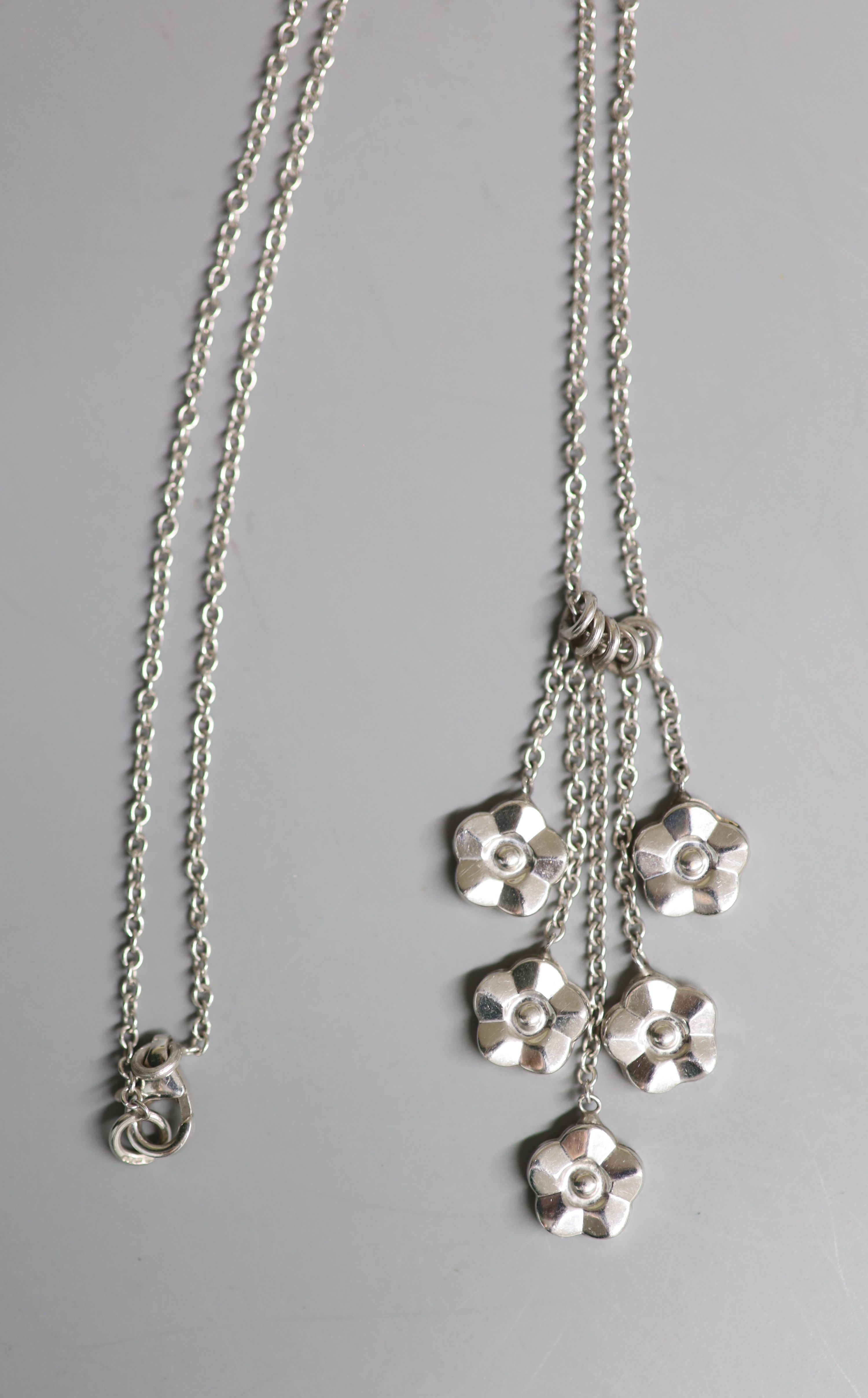 A modern 9ct white gold quintuple flower head cluster drop pendant, 40mm, on a 9ct white gold chain, 41cm, gross 4.9 grams.